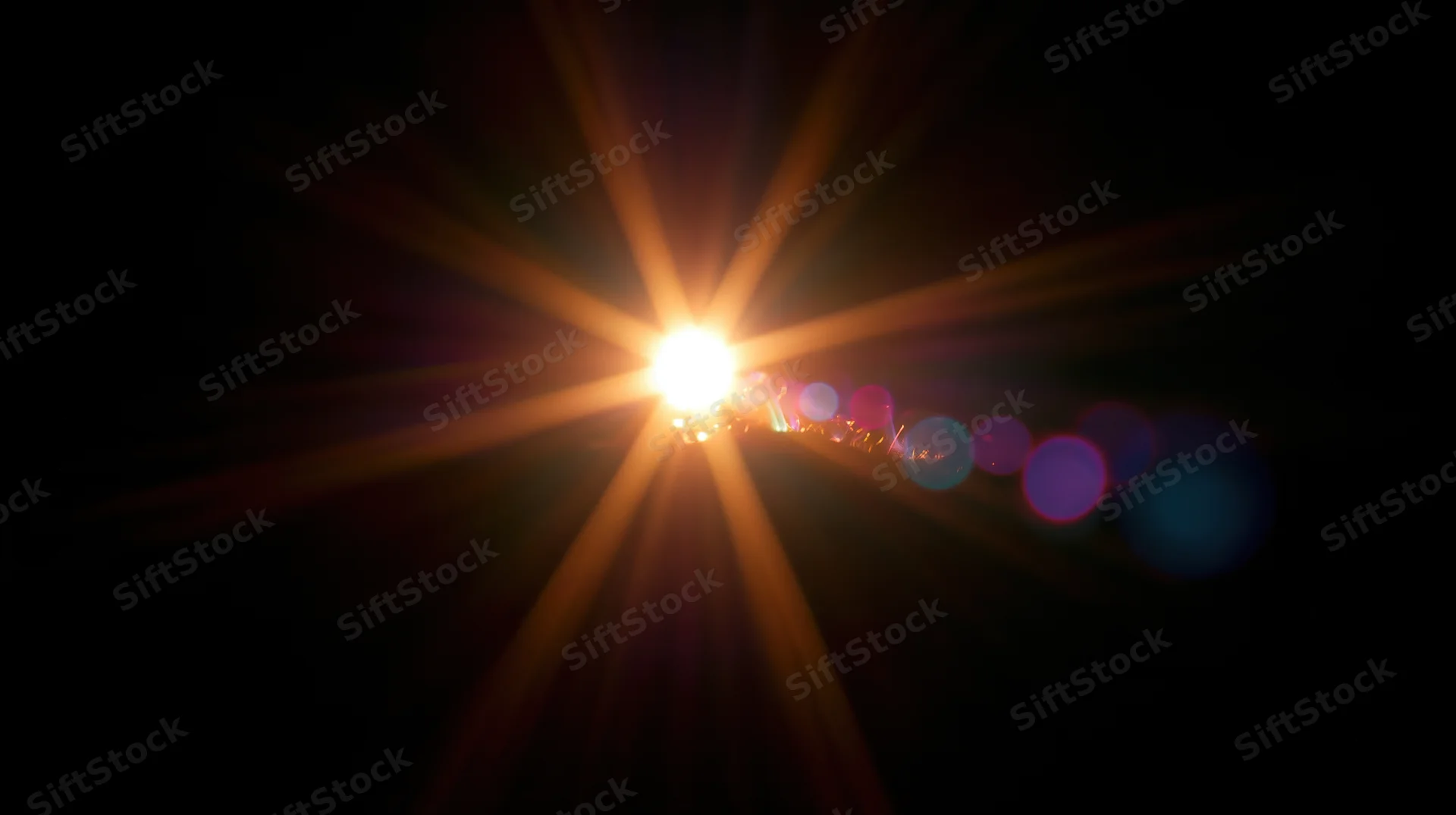 Bright light source with starburst flare and colorful bokeh circles against dark background