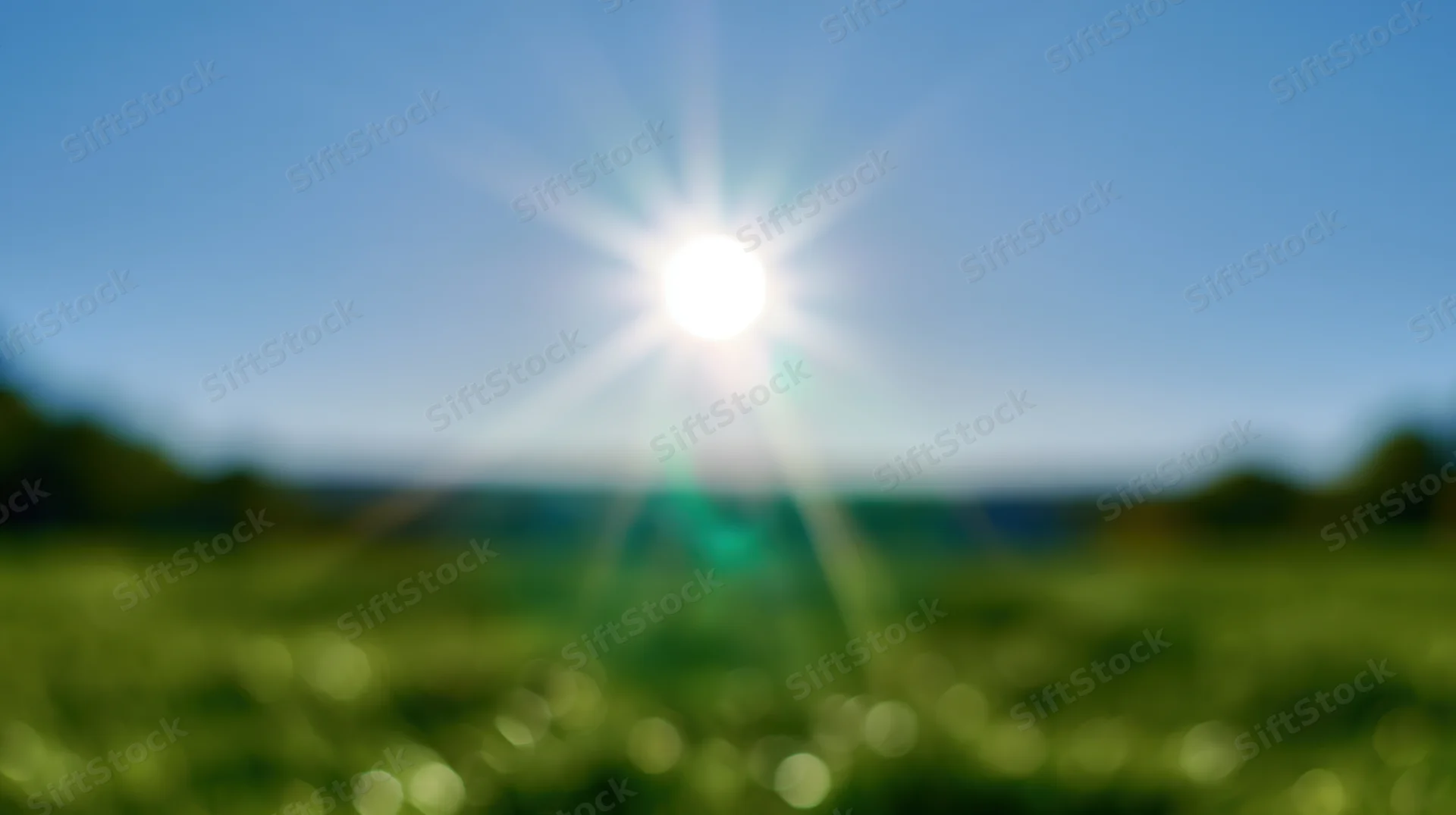 Bright sun shining over a green grassy field under a clear blue sky