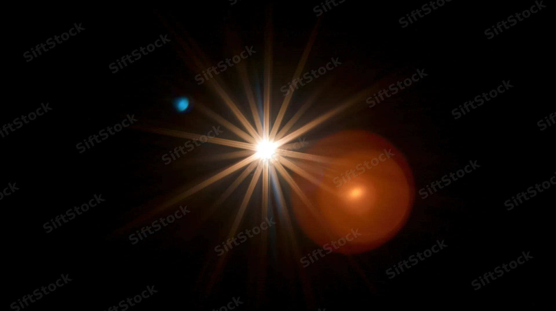 Bright star emitting radiant beams of light in dark space with lens flare and colored orbs