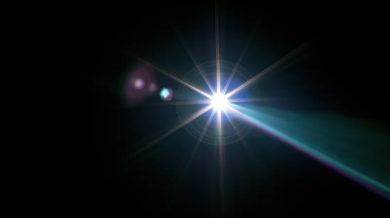 Bright starburst light flare against dark background with lens flare effects and blue purple rays