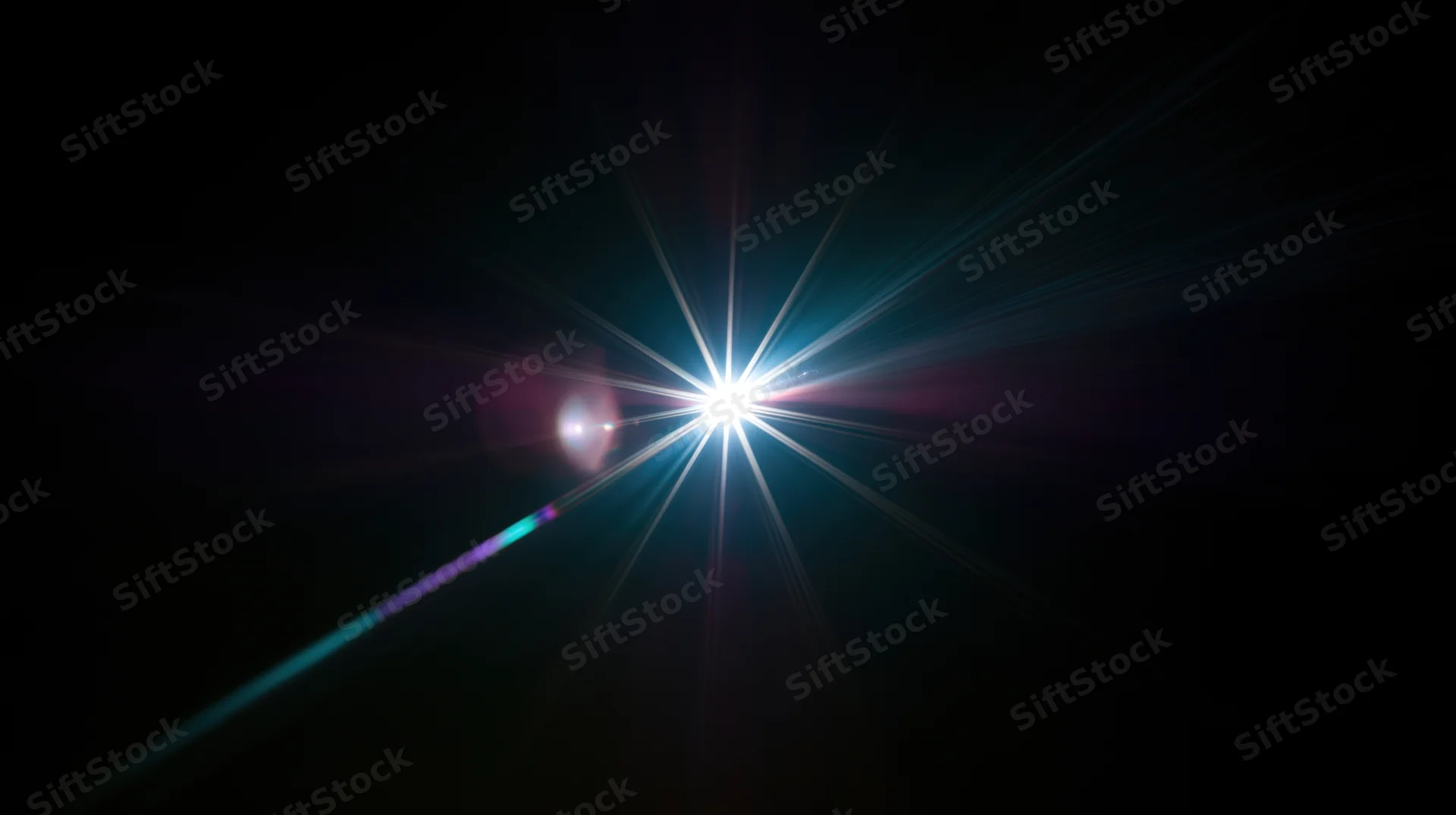 Bright starburst light flare radiating in dark space with colorful lens flares and beams