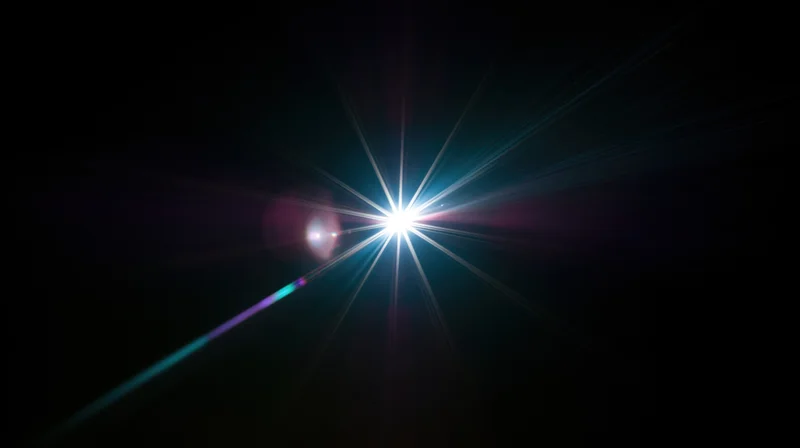 Bright starburst light flare radiating in dark space with colorful lens flares and beams