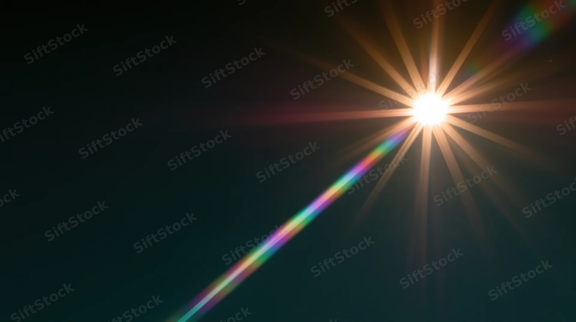 Bright starburst light flare with rainbow spectrum against dark background