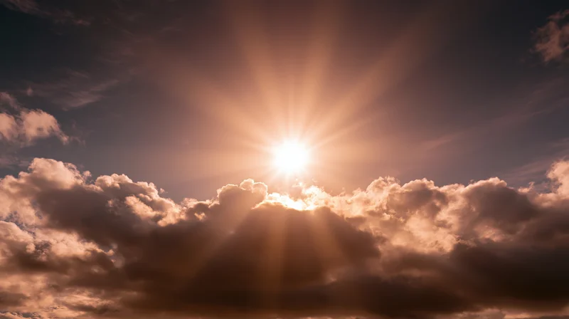 Sun shining through clouds in the sky at sunrise or sunset