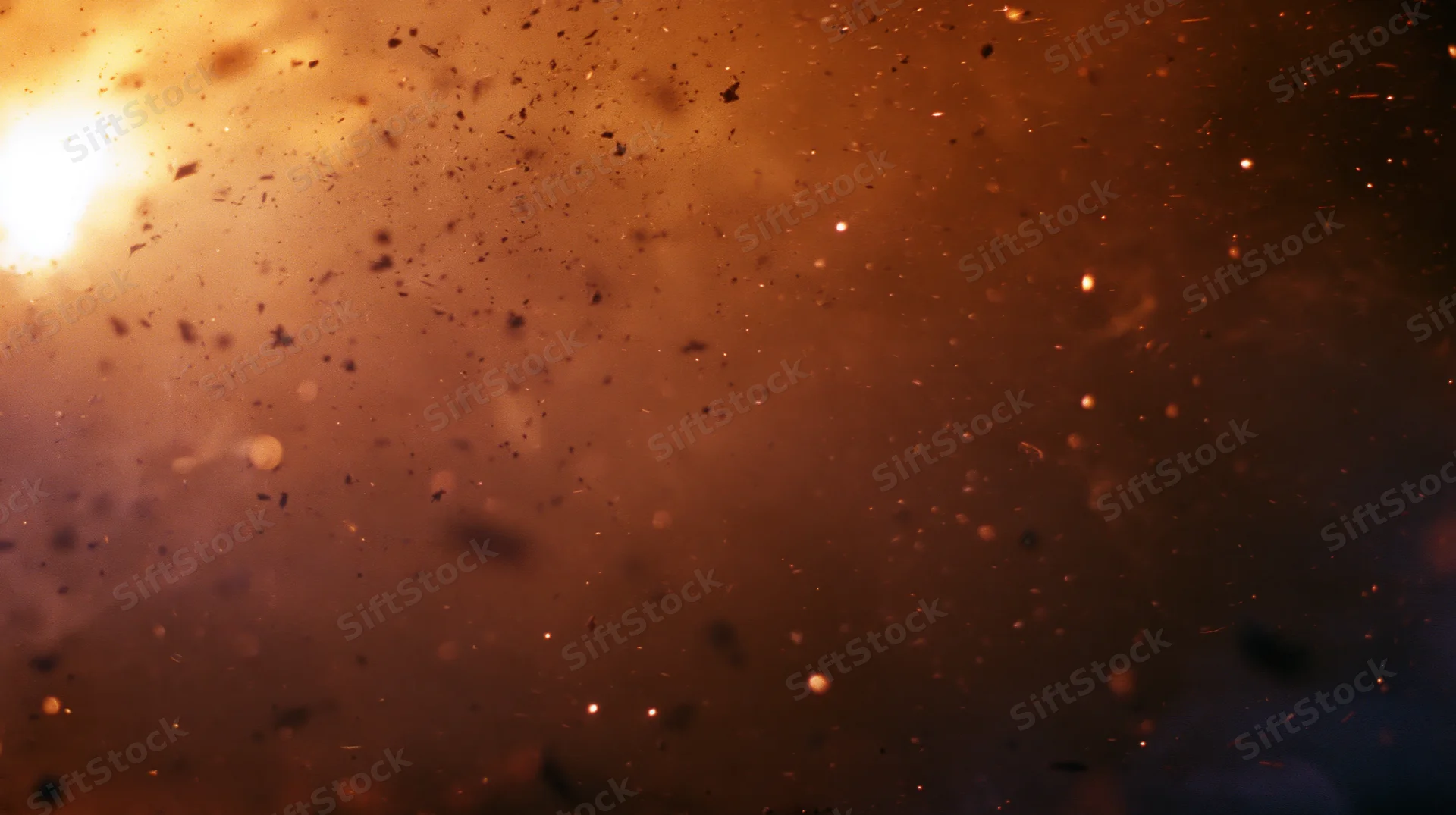 Fiery sparks and smoke floating in dark air with glowing embers and intense light source
