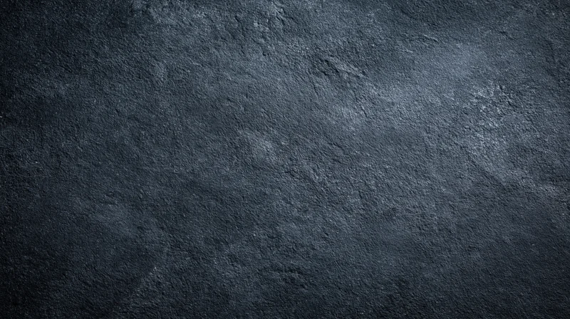 Dark textured stone surface with rough grainy finish as background