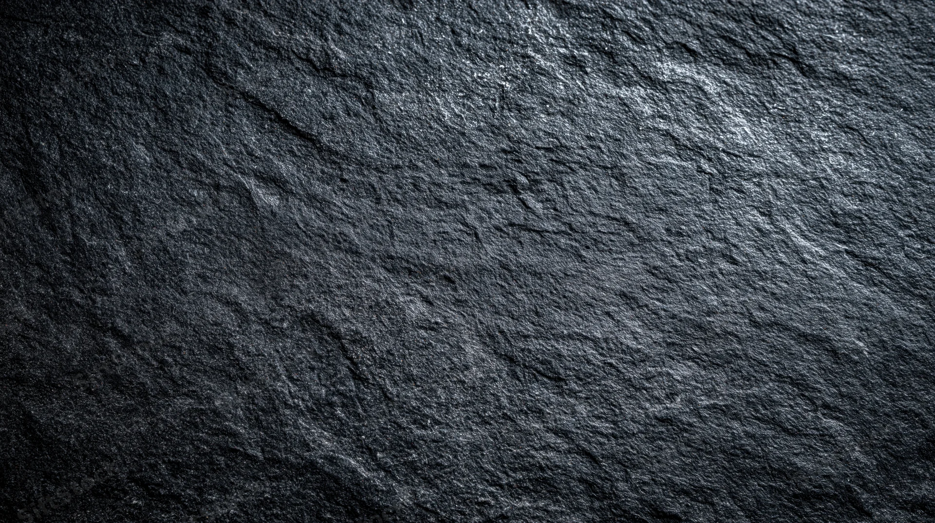 Close-up of dark slate stone surface with natural texture and rough grain