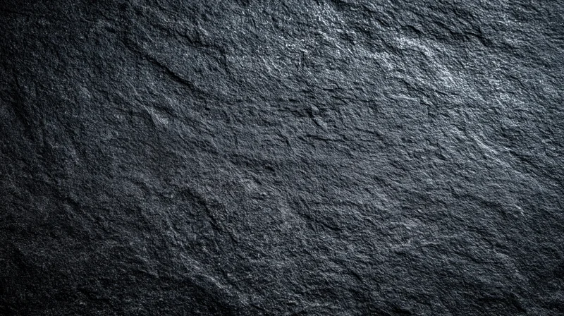 Close-up of dark slate stone surface with natural texture and rough grain