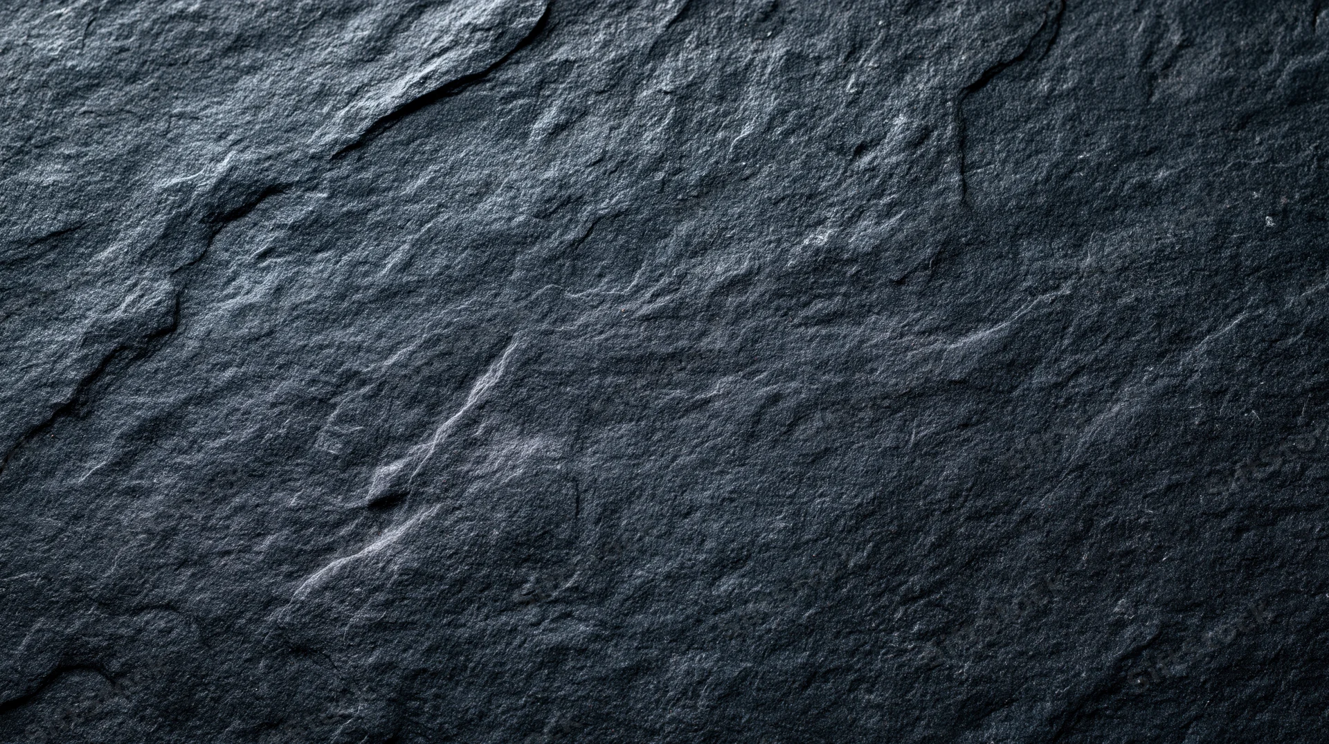 Dark slate stone surface with natural cracks and rough texture