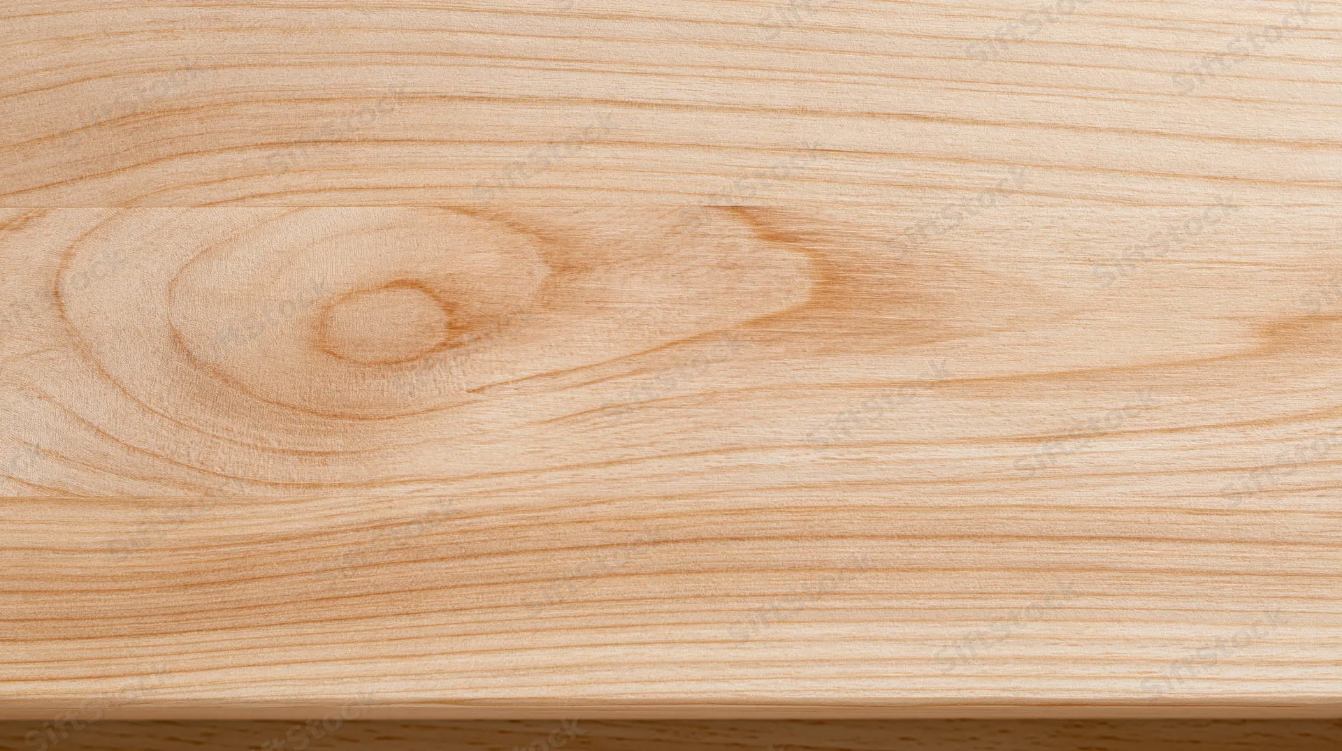 Closeup of light wood surface showing natural grain and knot pattern