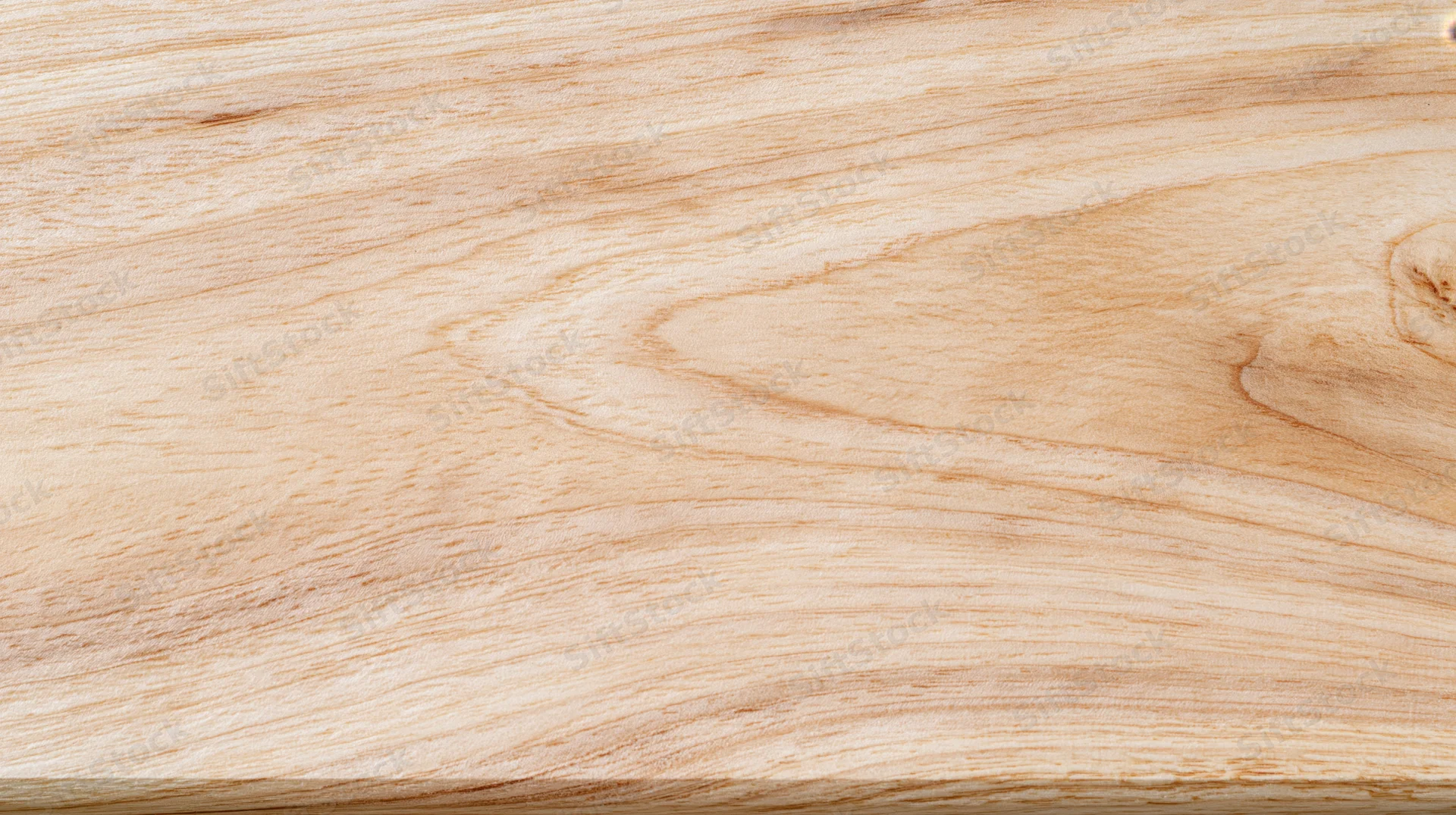 Close-up of light-colored wood surface showing natural grain pattern and smooth texture