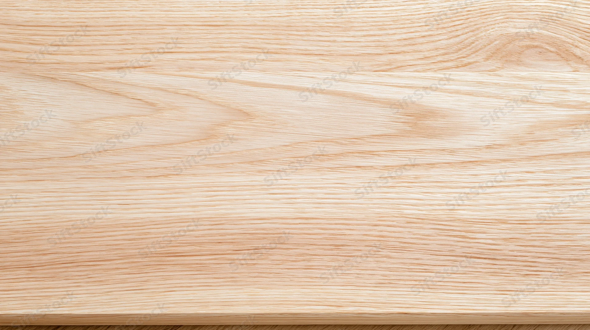 Closeup of light oak wood surface showing natural grain pattern and smooth finish
