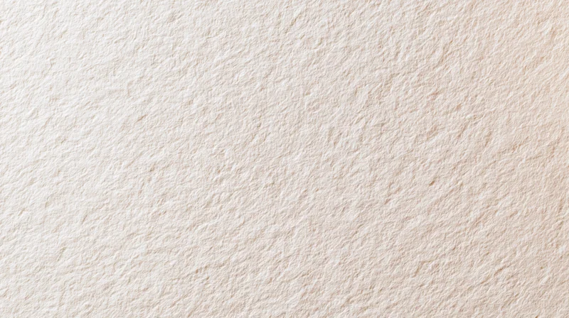 Textured beige surface filling the frame as a neutral background with subtle grain and even lighting