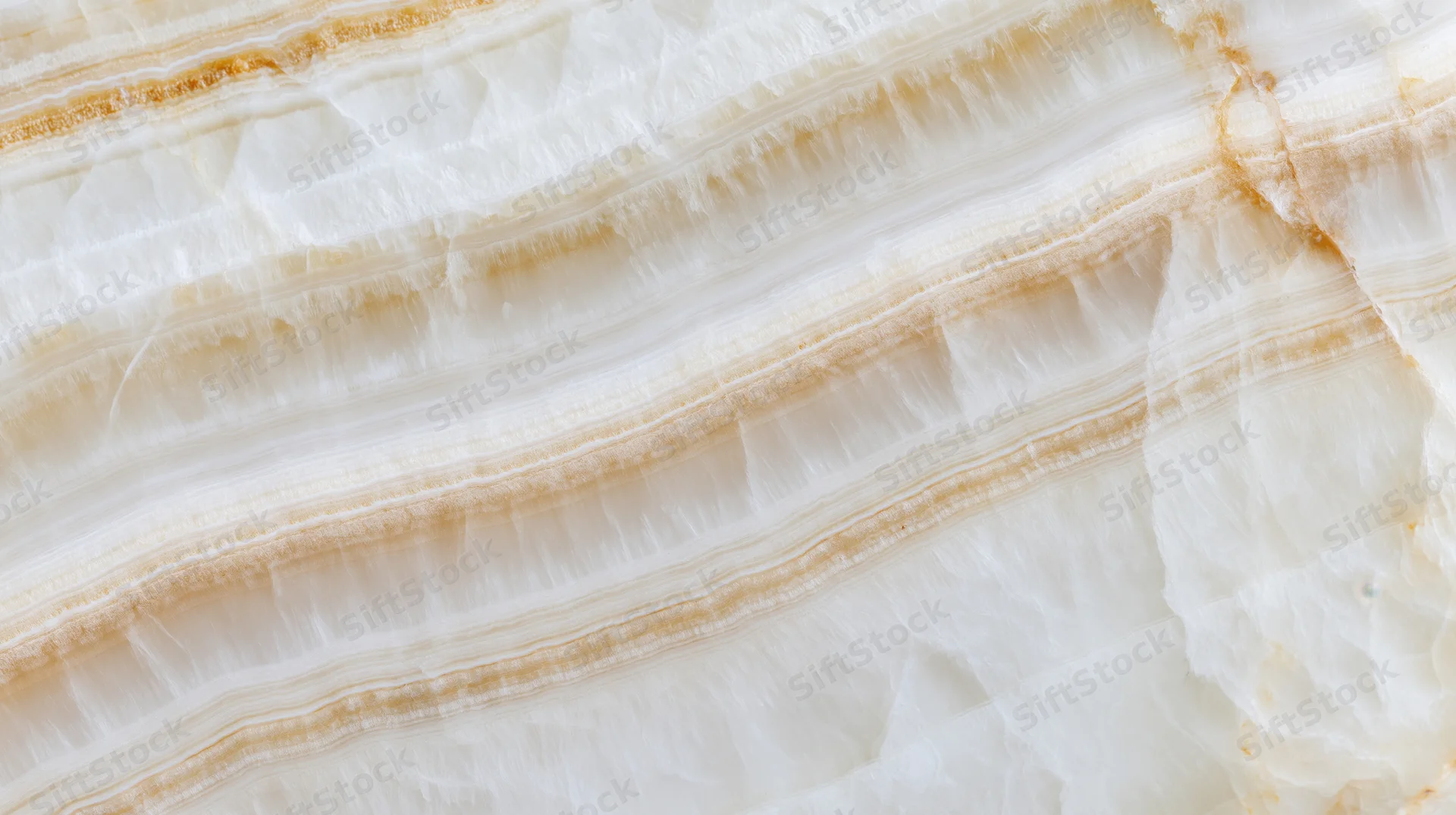 Close-up of layered white and beige onyx stone with natural veining and striations