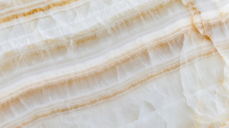Close-up of layered white and beige onyx stone with natural veining and striations