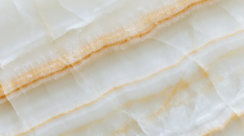 Closeup of white marble surface with golden veining and natural striations