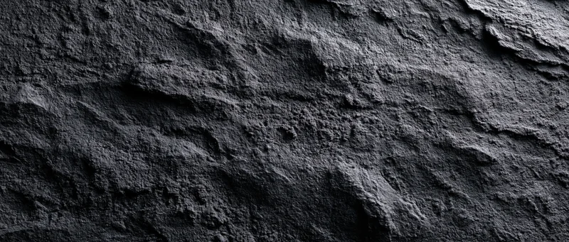 Closeup of dark rough stone surface with natural texture and layered formations