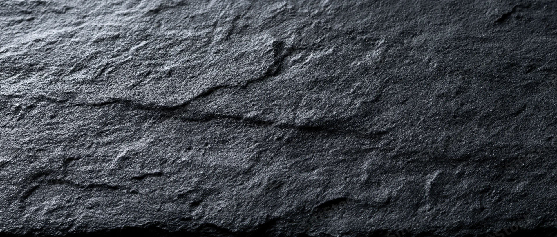 Dark textured stone surface with natural rugged pattern
