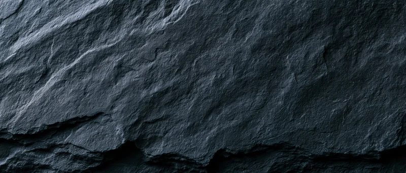 Dark slate rock surface with natural cracks and layered texture