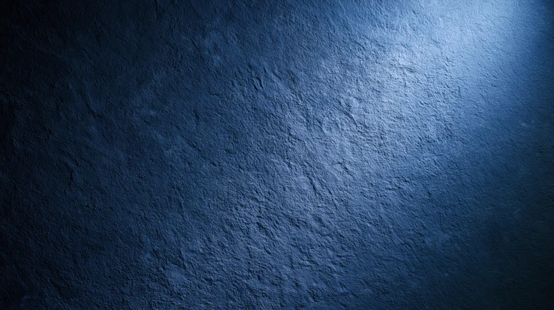 Textured blue stone wall illuminated by spotlight in dark interior