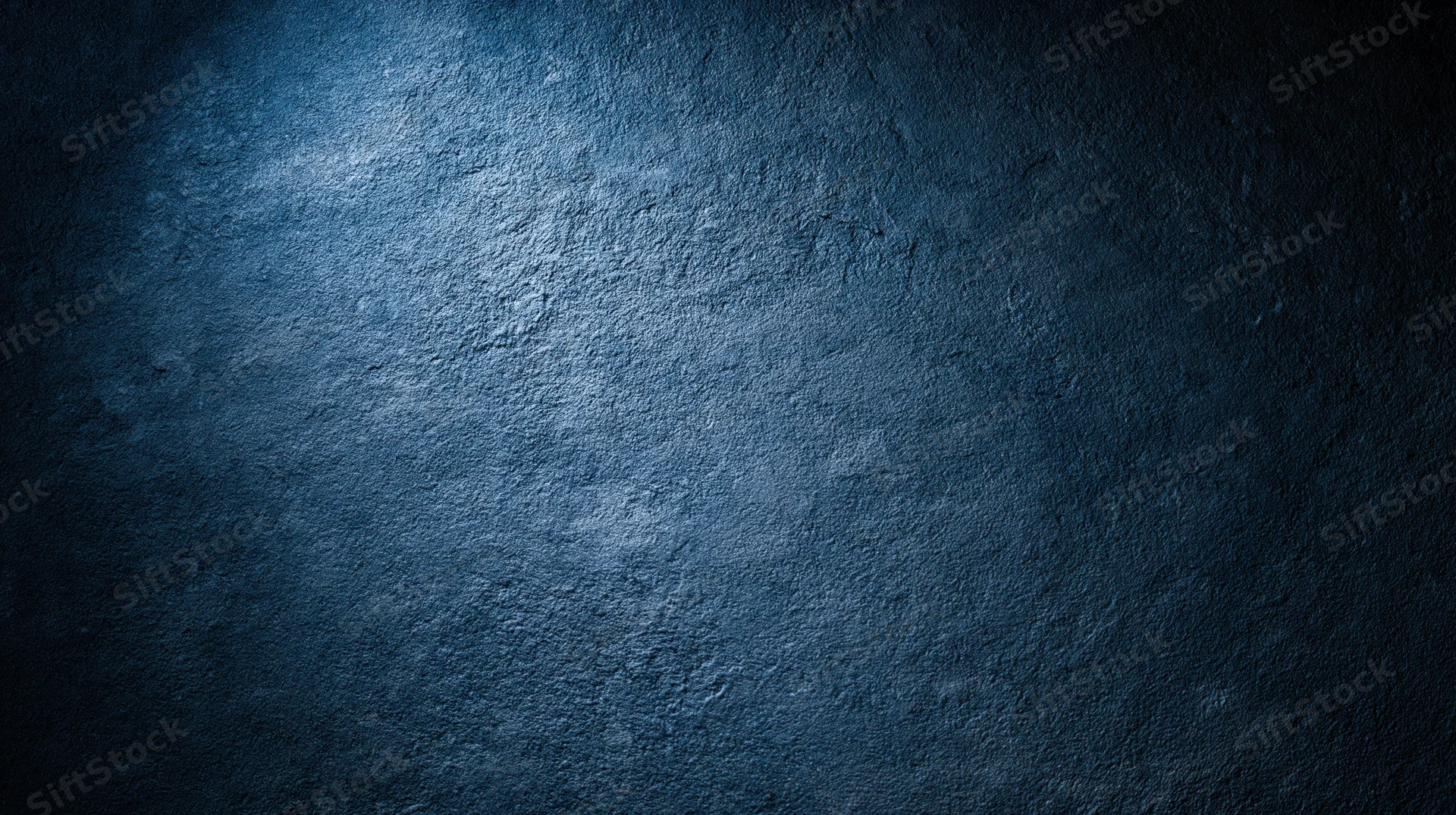 Textured blue concrete wall with spotlight and shadow, serving as a moody background