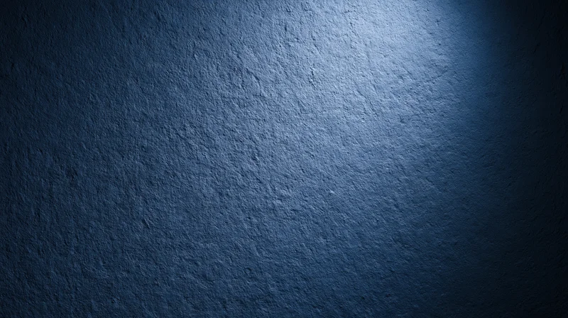 Textured blue wall illuminated by spotlight creating gradient shadow effect