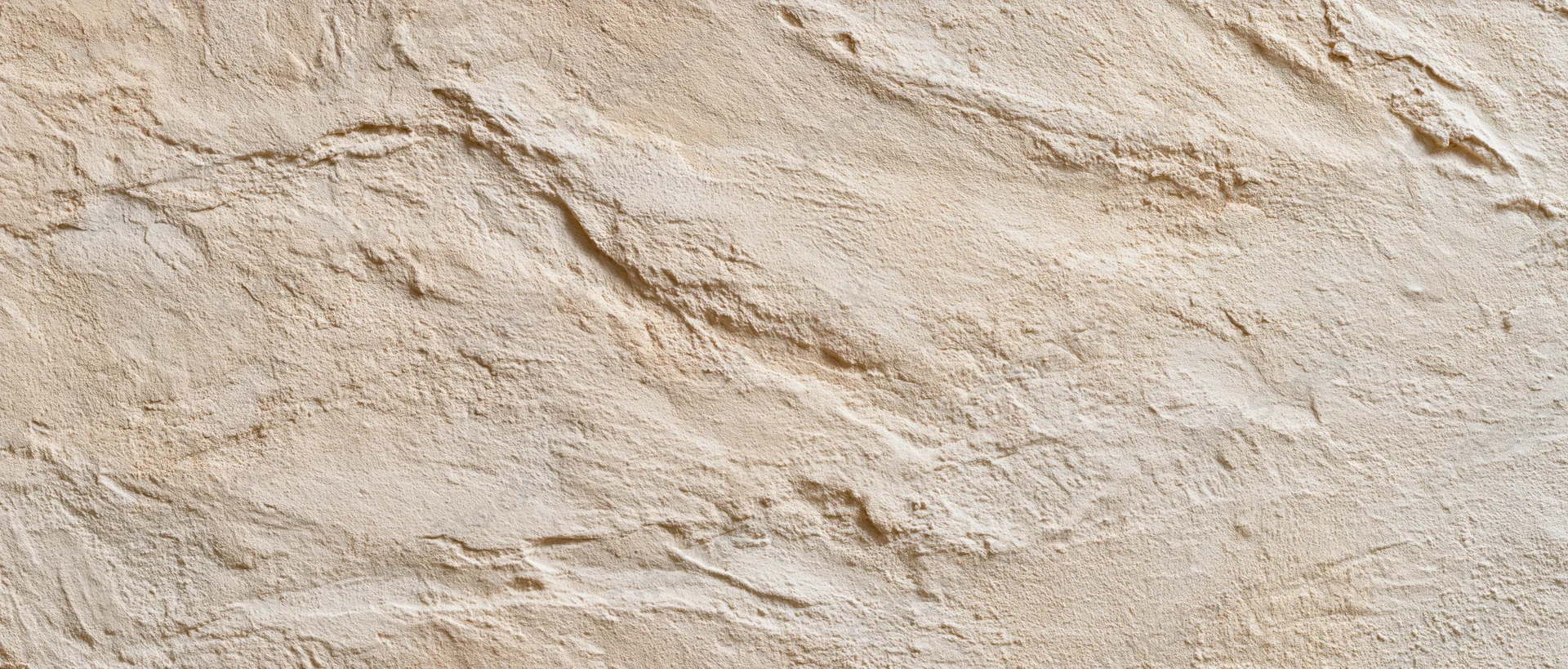 Textured plaster wall surface with uneven stucco finish in beige tone