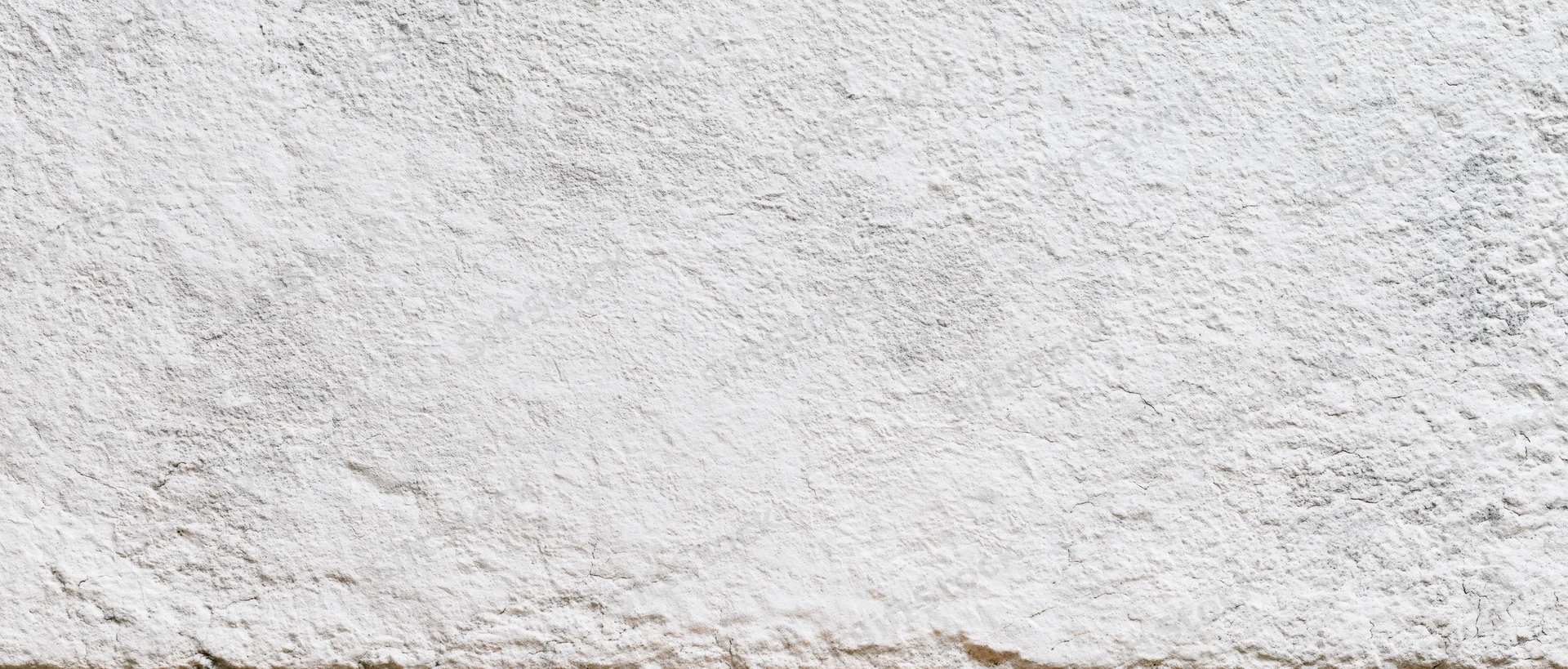 Close-up of a rough white plastered wall surface with uneven texture and subtle imperfections