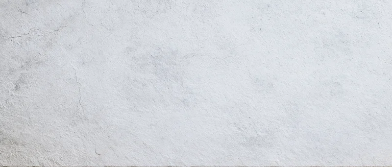 Textured concrete wall surface with cracks and weathered finish