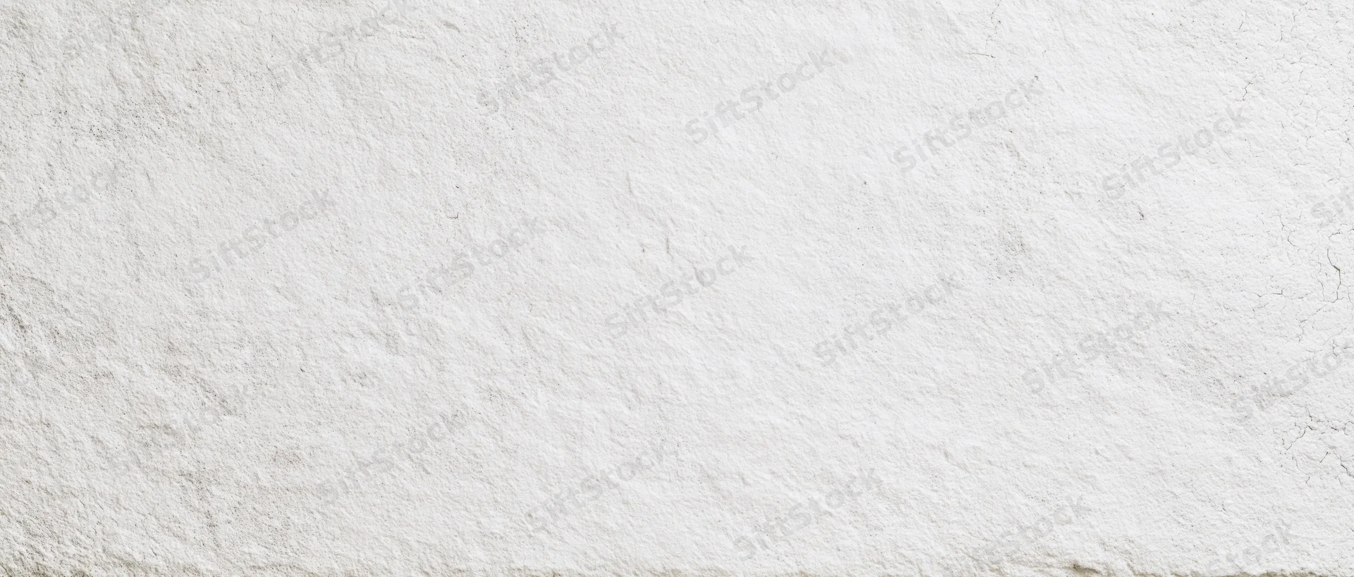 Textured white plaster wall surface with cracks and uneven finish