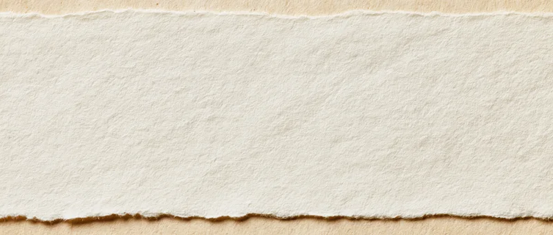 Torn edge of white paper on beige background with copyspace