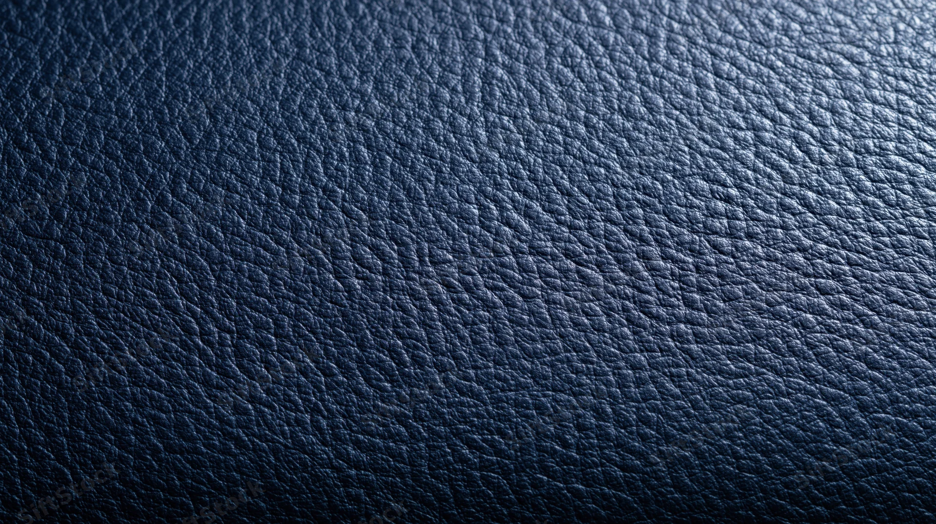 Closeup of dark blue leather texture with visible grain pattern
