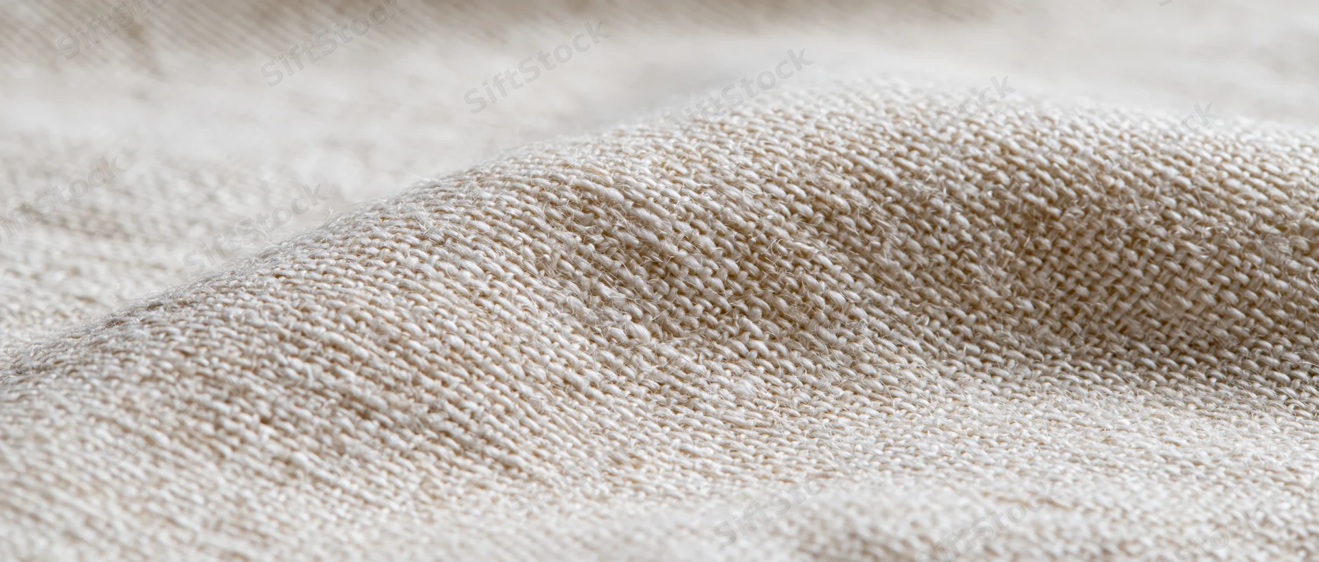 Closeup of beige knitted fabric with visible texture and weave pattern