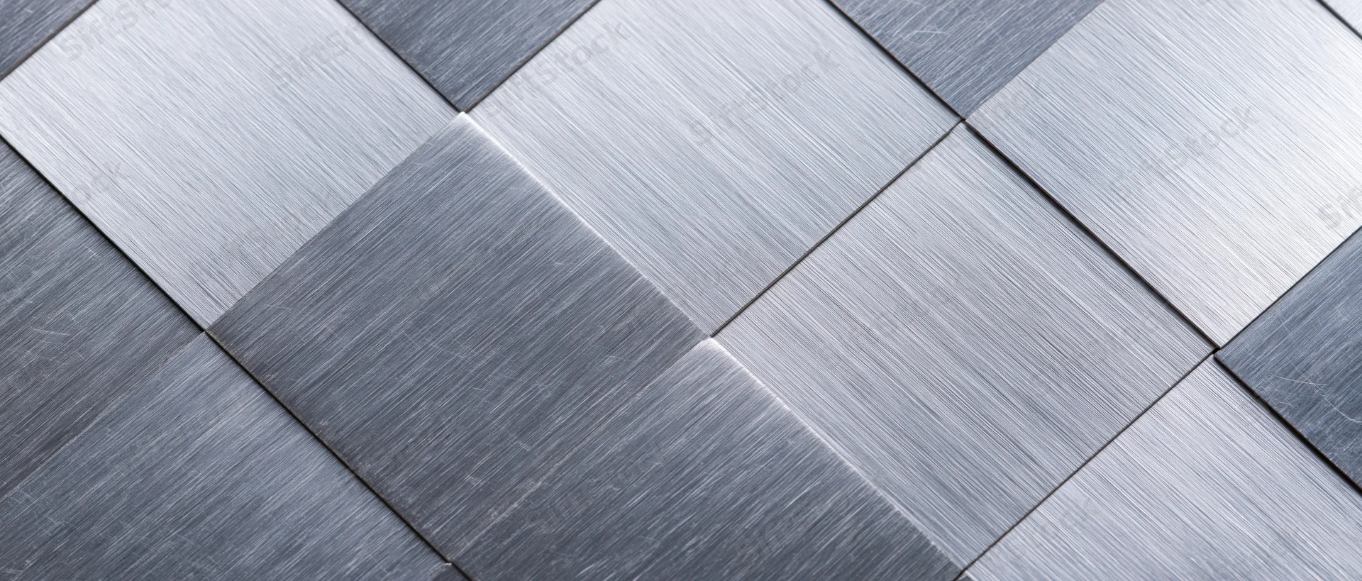 Brushed metal tiles arranged in a geometric grid pattern on a flat surface