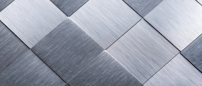 Brushed metal tiles arranged in a geometric grid pattern on a flat surface