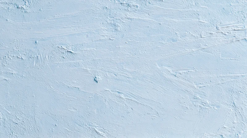 Close-up of a smooth white painted wall with visible brushstrokes and subtle texture, used as a background