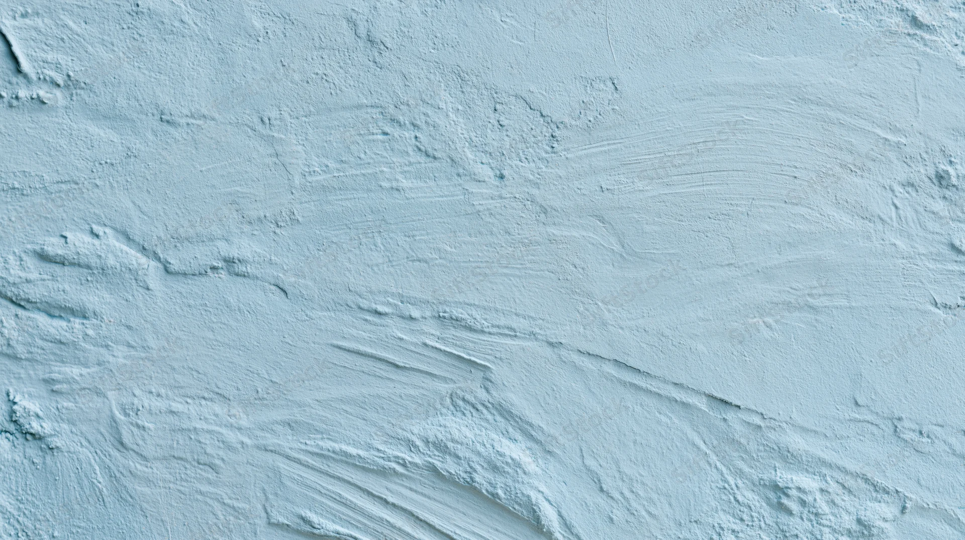 Light blue painted wall with visible brushstrokes and textured plaster finish