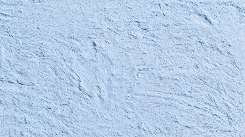 Textured blue plaster wall surface with rough uneven finish