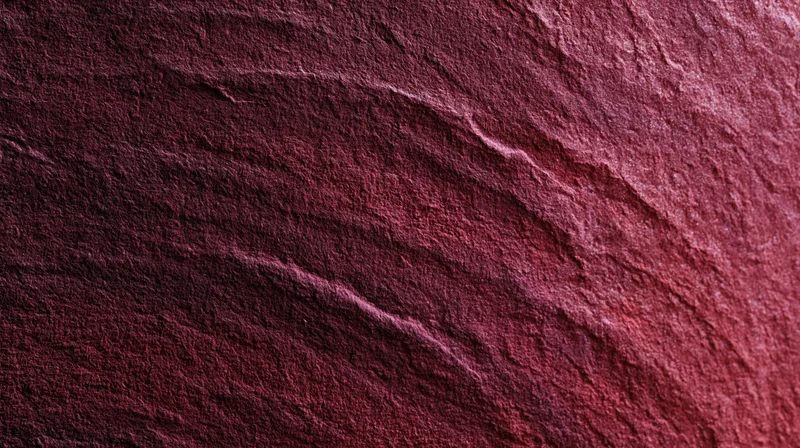 Closeup of red stone surface with natural striations and rough texture
