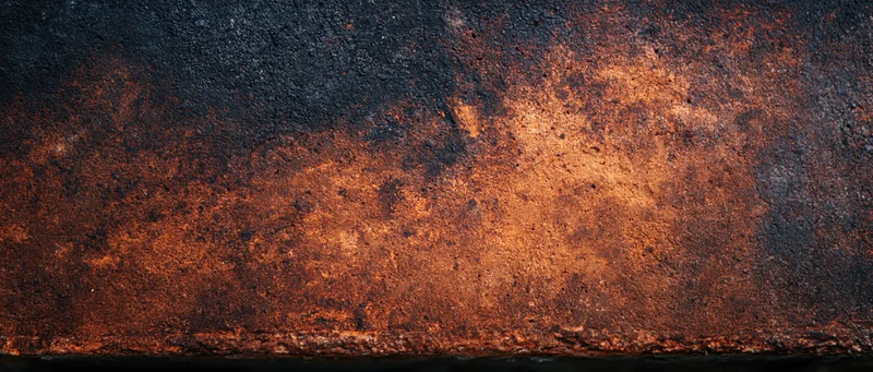 Rusted metal surface showing corrosion and weathering with dark and orange tones