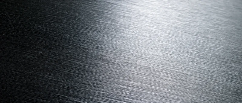 Brushed metal surface with linear texture and light gradient