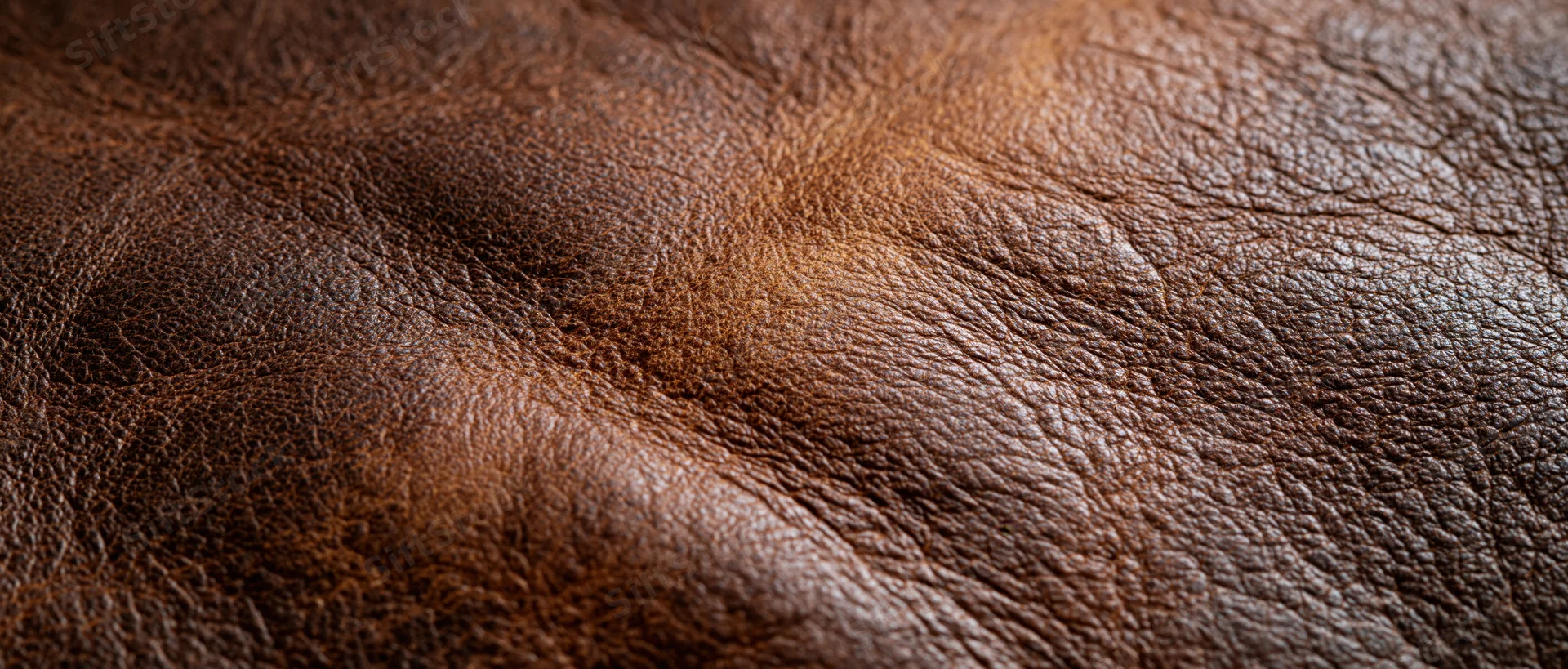 Closeup of brown leather surface showing natural grain and texture