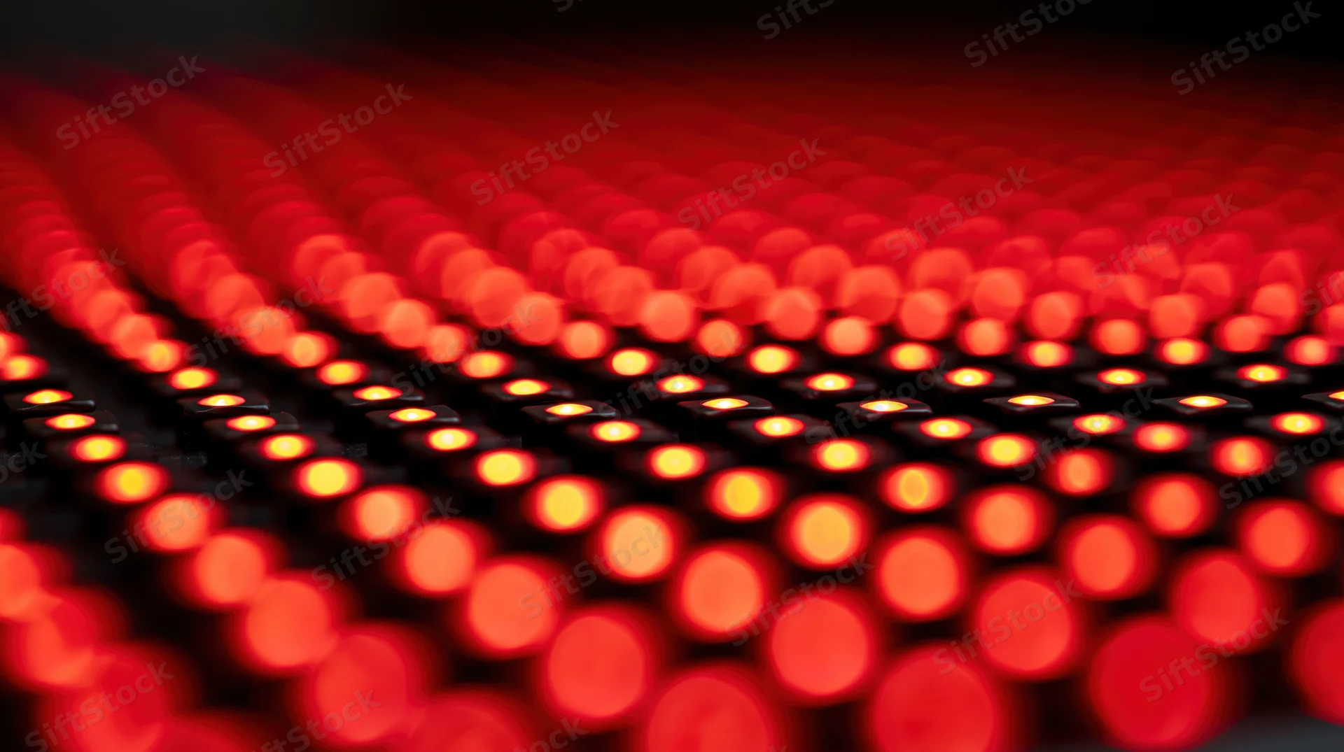 Rows of red led lights arranged in a grid with shallow depth of field creating bokeh effect