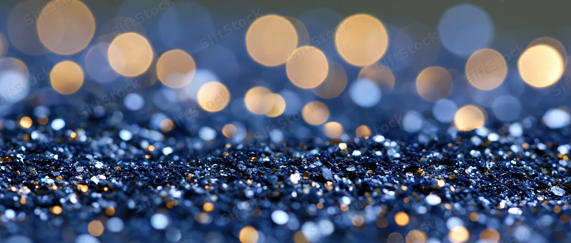 Blue glitter surface with golden bokeh lights in background