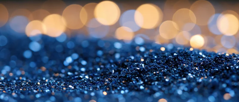 Blue glitter surface with warm bokeh lights in background