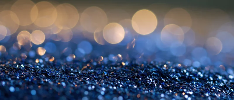 Blue glitter surface with bokeh lights in background