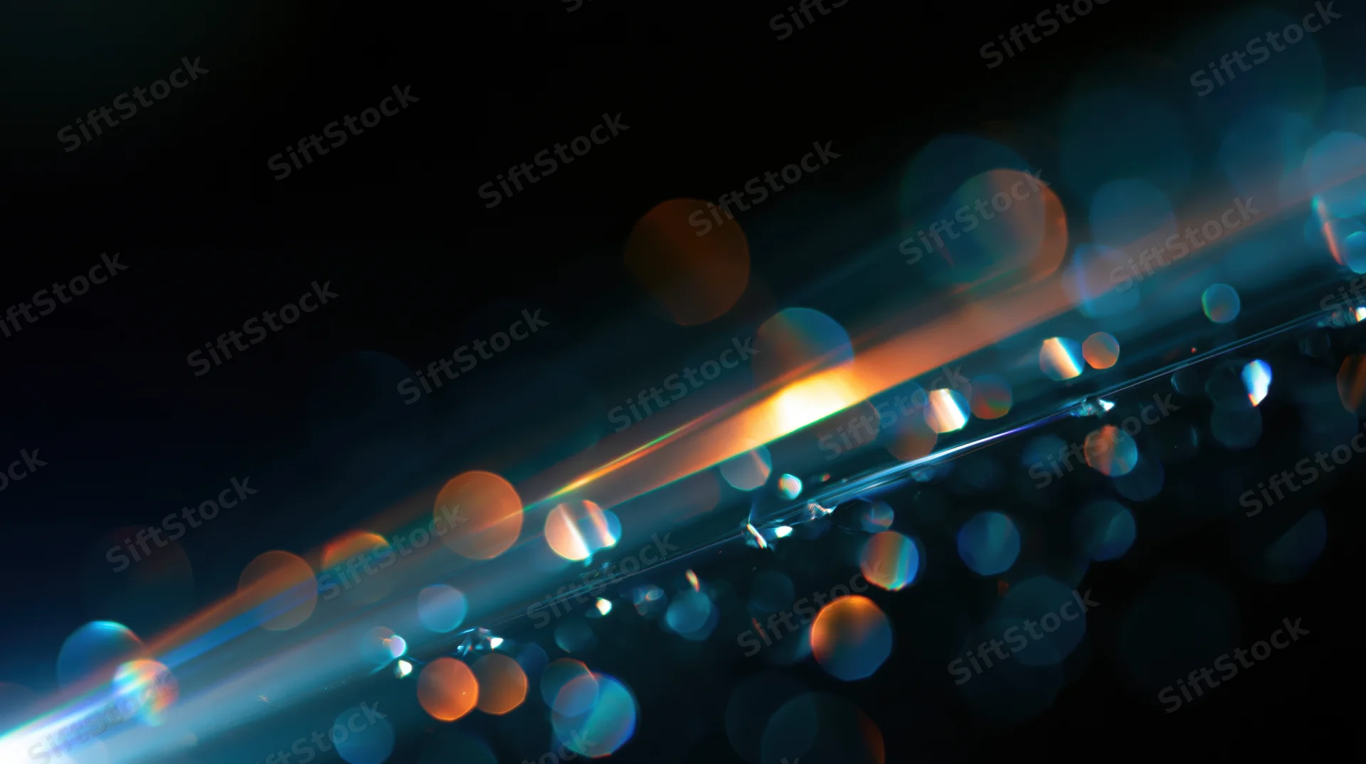 Abstract bokeh lights glowing in dark background with soft focus and lens flare effects