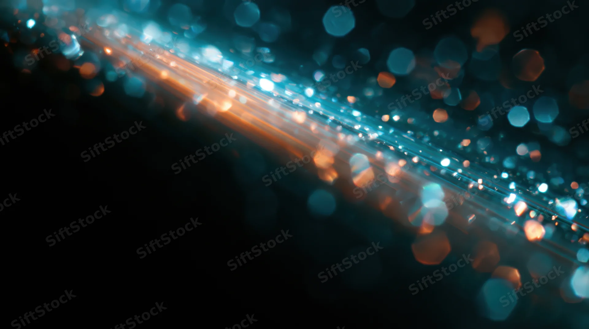 Abstract bokeh lights in blue and orange hues on dark background with copyspace