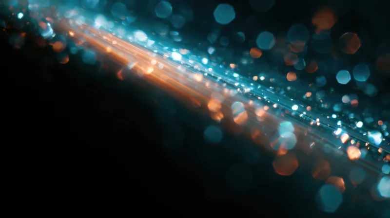 Abstract bokeh lights in blue and orange hues on dark background with copyspace