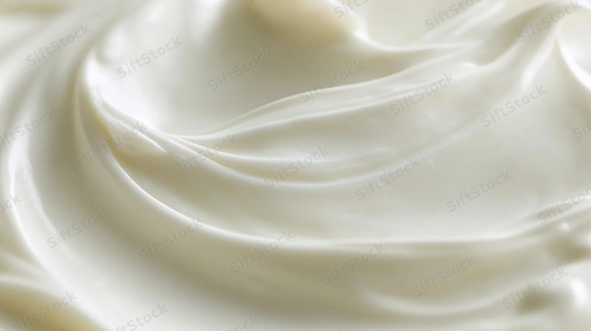 Close-up of smooth white cream in swirling pattern filling the frame